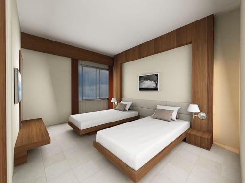 ein Schlafzimmer mit zwei Betten und einem Fenster in der Unterkunft Neeshorgo Hotel & Resort in Cox's Bazar