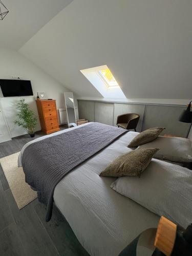 une chambre avec un grand lit avec une lucarne dans l'établissement Le Haras proche de Wimereux et Wissant, à Beuvrequen