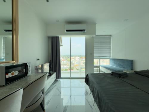 a hotel room with a bed and a large window at Новые апартаменты Empire Tower in Jomtien Beach