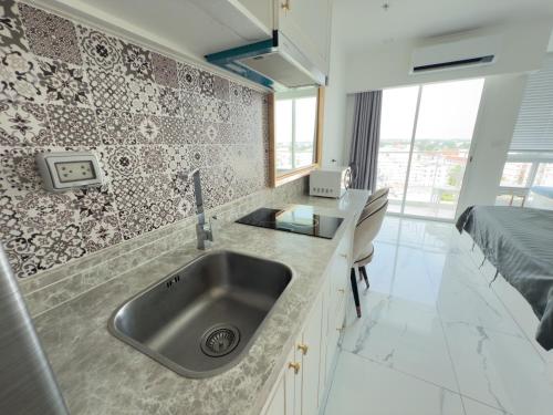 a kitchen with a sink and a bed in a room at Новые апартаменты Empire Tower in Jomtien Beach