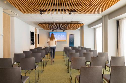 a woman walking through a room with chairs at Belaroïa Montpellier Centre Saint Roch in Montpellier