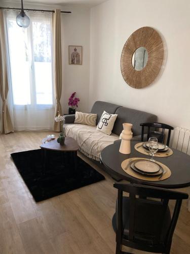 un salon avec un canapé et une table dans l'établissement Fully-equipped studio Paris Disneyland RER E RER A, à Le Perreux-Sur-Marne