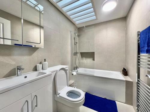 a bathroom with a toilet and a tub and a sink at Wonderful Oxford Jericho 3 Bedroom House with Parking and Private Garden in Oxford