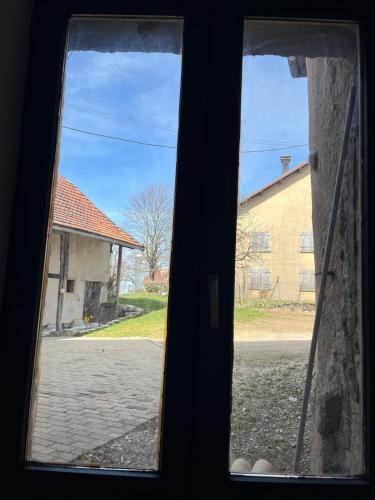 Elle offre une vue sur une rue et un bâtiment. dans l'établissement La Grange du Tanneur, à Fraroz