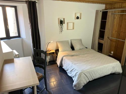 une petite chambre avec un lit et une table dans l'établissement La Grange du Tanneur, à Fraroz