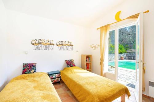 - 2 lits dans une chambre avec une fenêtre et une piscine dans l'établissement Villa Bois Tranquille by Villa Plus, à Bagnols-en-Forêt