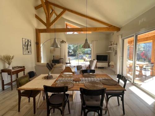 un salon avec une table et des chaises en bois dans l'établissement Charmante maison en bois, à Léon