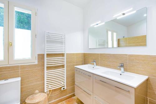 une salle de bain avec un lavabo et un miroir dans l'établissement Villa Bois Tranquille by Villa Plus, à Bagnols-en-Forêt