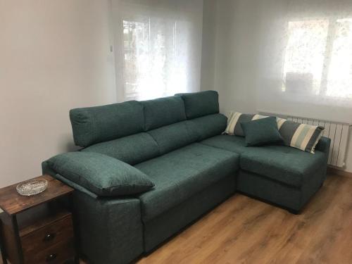 a green couch sitting in a living room at O Fogar do Moucho - Tres Marias Apartments in Redondela
