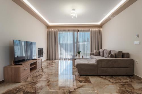 a living room with a couch and a flat screen tv at Zante Diamond Resort in Zakynthos Town
