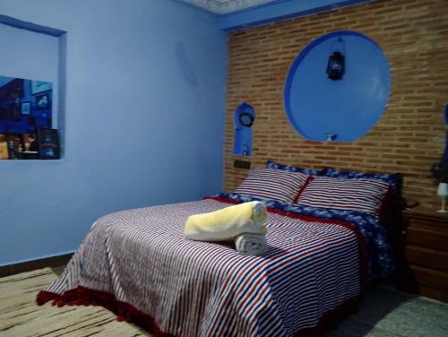 a bedroom with a bed with a stuffed animal on it at Blue House Town in Chefchaouene
