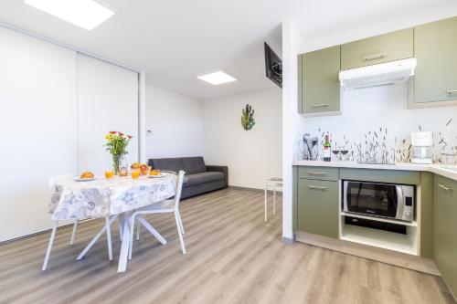 une cuisine et un salon avec une table et un canapé dans l'établissement L'îlot Narrossais - Idéal Curistes - 6, à Narrosse