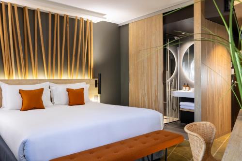a bedroom with a large white bed and a bench at Belaroïa Montpellier Centre Saint Roch in Montpellier