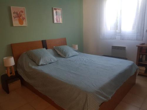 - une chambre avec un lit doté de draps bleus et de 2 oreillers dans l'établissement Mini villa T2, 200 m de la plage, piscine chauffée, jardin, à Prunete