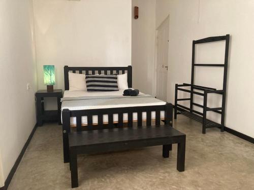 a bedroom with a bed and a bench in it at Villa Inlet Galle in Galle