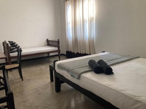 a bedroom with two beds and a couch and a chair at Villa Inlet Galle in Galle