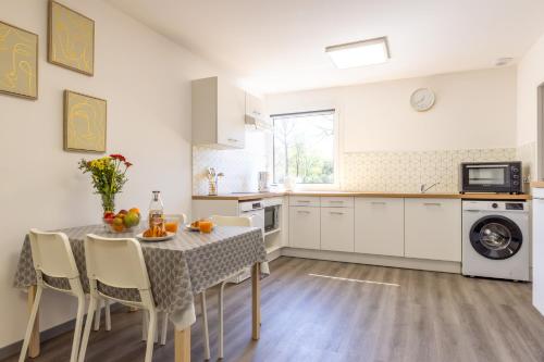 une cuisine avec une table et des chaises dans une cuisine dans l'établissement L'îlot Narrossais - Idéal Curistes - 7, à Narrosse