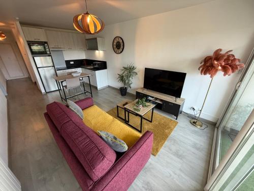 - un salon avec un canapé et une télévision dans l'établissement Appartement au bord de mer, à Saint-Brévin-les-Pins