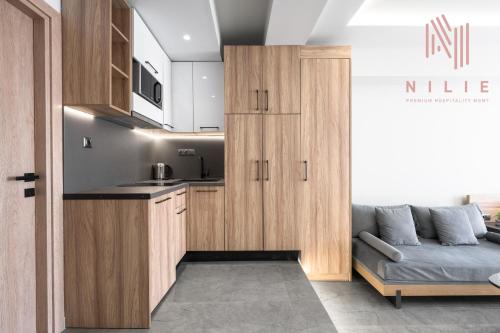 a kitchen with wooden cabinets and a couch in a room at Pantheon, Nilie Hospitality MGMT in Thessaloniki