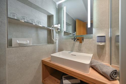 a bathroom with a white sink and a shower at Hotel Weinbauer in Schwangau