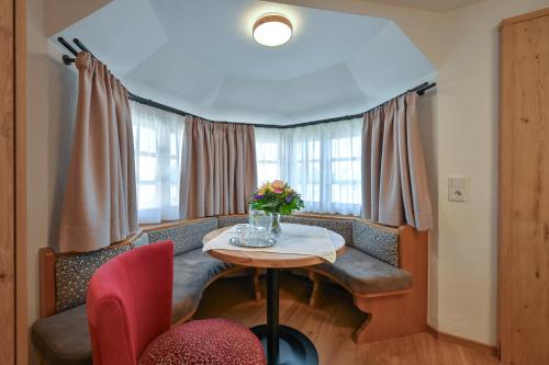 a dining room with a table with flowers on it at Hotel Weinbauer in Schwangau