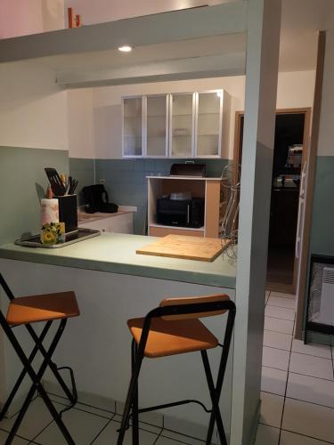 une cuisine avec deux tabourets sur un comptoir de cuisine dans l'établissement Agréable maison familiale, à La Louptière-Thénard