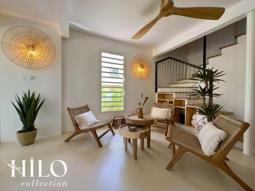 a living room with chairs and a spiral staircase at HILO Villa Lagon de l'Hermitage Nomade in L'Ermitage-Les-Bains