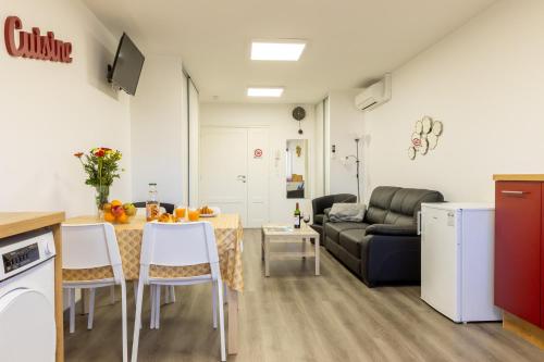 une cuisine et un salon avec une table et un canapé dans l'établissement L'îlot Narrossais - Idéal Curistes - 4, à Narrosse