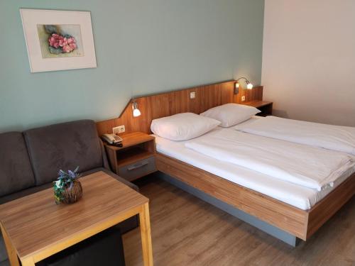 a small bedroom with a bed and a couch at Dolomitenhotel Lienz in Lienz