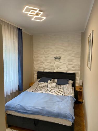 a bedroom with a large bed with blue sheets at Szemes Villa in Balatonszemes