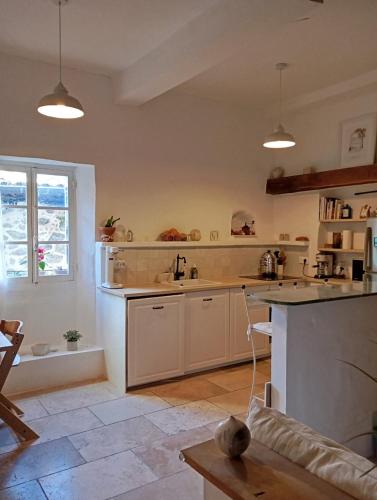 une cuisine avec des armoires blanches et un comptoir dans l'établissement Maison climatisée au coeur du village, à Cagnes-sur-Mer