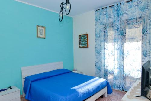 - une chambre bleue avec un lit et une télévision dans l'établissement Casa Mary - De Vivo Realty Meta di Sorrento, à Meta