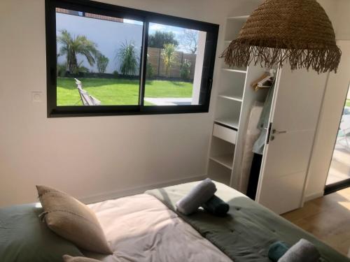 une chambre avec un lit et une grande fenêtre dans l'établissement La villa'gapanthe, à Sarzeau