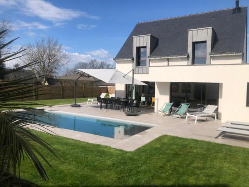 une maison avec une piscine dans la cour dans l'établissement La villa'gapanthe, à Sarzeau
