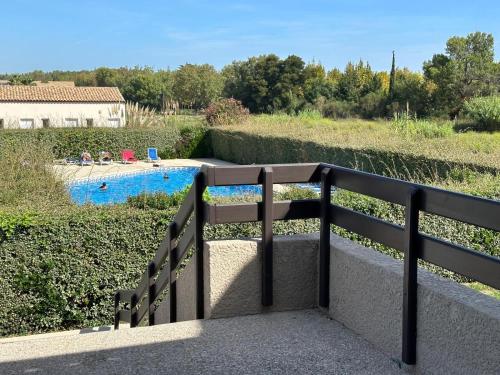 un banc sur un pont avec une piscine dans l'établissement L'ECUME DES VAGUES- Spacieux 3 chambres Familial Tout Confort au Calme, Climatisé et Piscine, adapté au télétravail, à Saint-Cyprien
