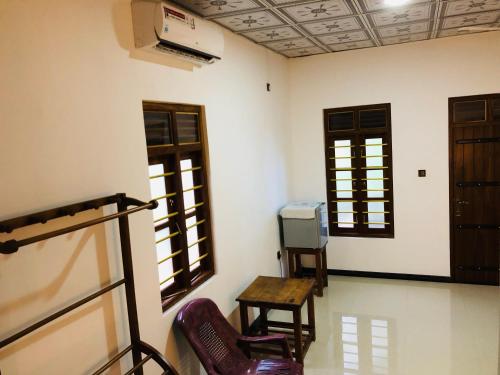 a room with a table and chairs and windows at Calm Garden Cabanas in Tangalle