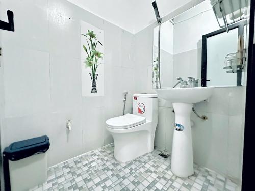 a white bathroom with a toilet and a sink at Noi Bai Sunflower Hotel in Noi Bai