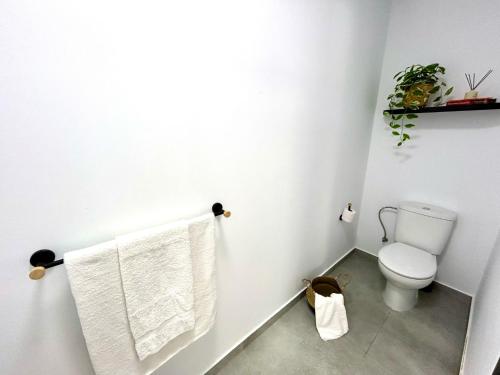 a bathroom with a toilet and towels on a wall at AZUL in Bolnuevo