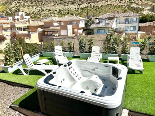 a bath tub sitting on top of a lawn with chairs at AZUL in Bolnuevo