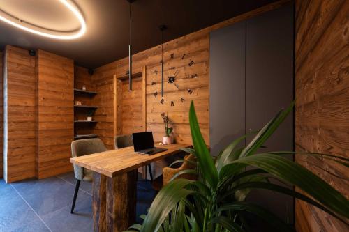 an office with a wooden table with a laptop on it at Ca' Leonardi II - Ledro in Tiarno di Sotto