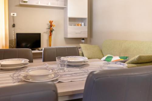 a dining room table with plates on top of it at Casabb in Toscolano Maderno