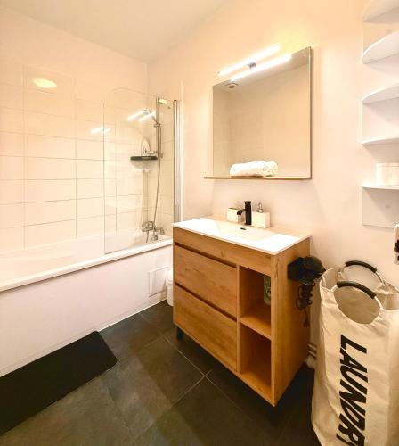 une salle de bain avec un lavabo, une douche et un miroir dans l'établissement Champs Élysées appartement 5, à Paris