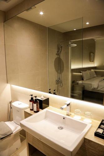 a bathroom with a sink and a large mirror at Ow! Hotel Boutique Kemayoran in Jakarta