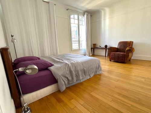 une chambre avec un lit, une chaise et une fenêtre dans l'établissement Le Penthouse Guy Moquet, à Paris