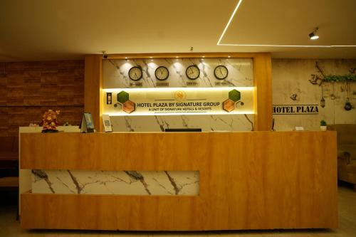 a counter in a room with clocks on the wall at Hotel Plaza Hyderabad Airport Zone in Shamshabad