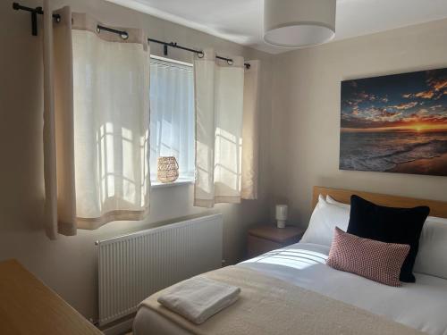 une chambre avec un lit et un tableau au mur dans l'établissement 2 Bedroom Townhouse near Cardiff Bay and City Centre with Garden and Parking, à Cardiff