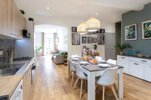 une cuisine et un salon avec une table et des chaises dans l'établissement #34 Lamartine Central 3 Bdrs AC balcony 10mins walk to old town, à Nice