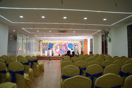a room full of chairs with a stage in the background at Hotel Plaza Hyderabad Airport Zone in Shamshabad
