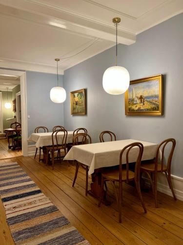 a dining room with tables and chairs and lights at Hotel Klostergaarden in Allinge