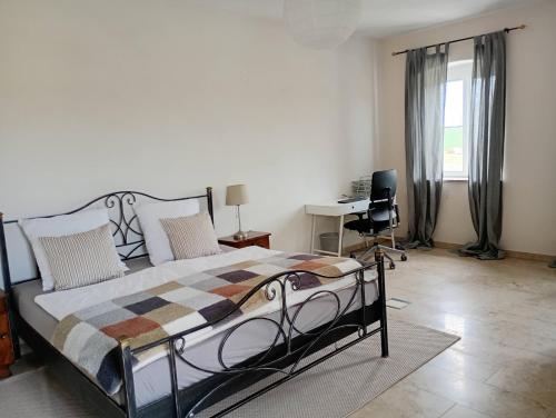 une chambre avec un lit, un bureau et une fenêtre dans l'établissement Cottage Living, à Leiblfing